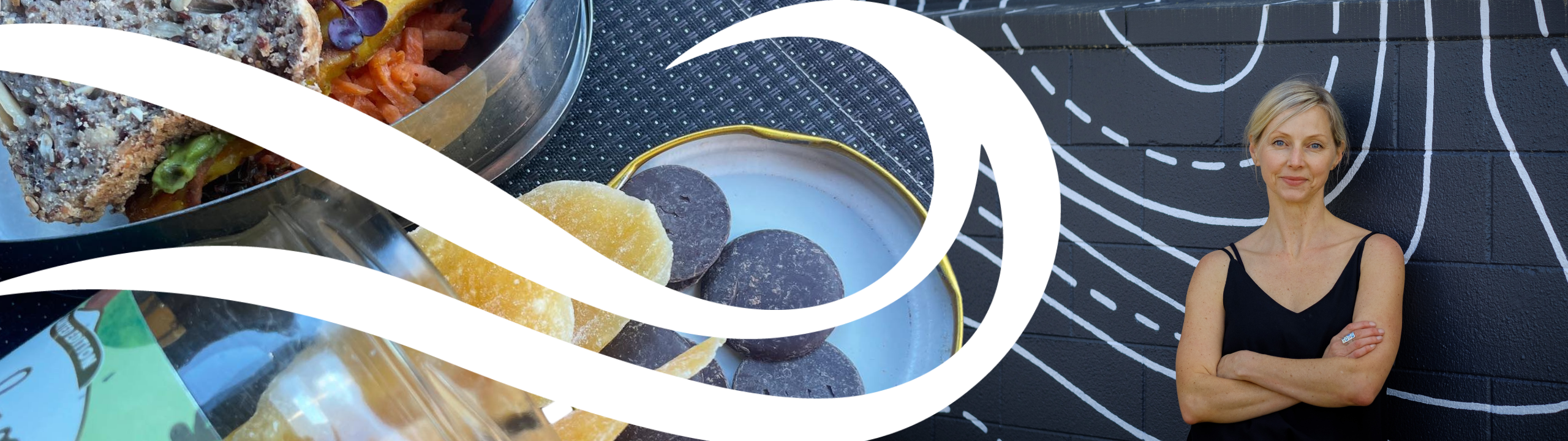 A woman in black stands confidently against a mural wall, with arms crossed. On the left, close-up of plated food includes sandwiches and desserts. Abstract white waves overlay the image.